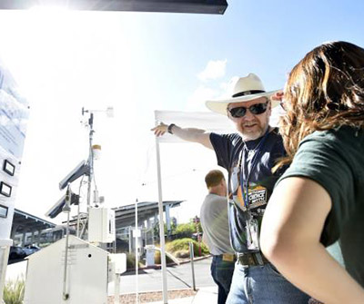 A CEMP volunteer explains equipment to a May the Science Be With You attendee at the outreach event on the DRI Las Vegas Campus. 